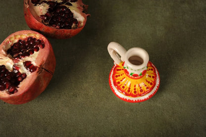 Hand-painted ceramic candlestick on green fabric with pomegranate, artisan clay home decor