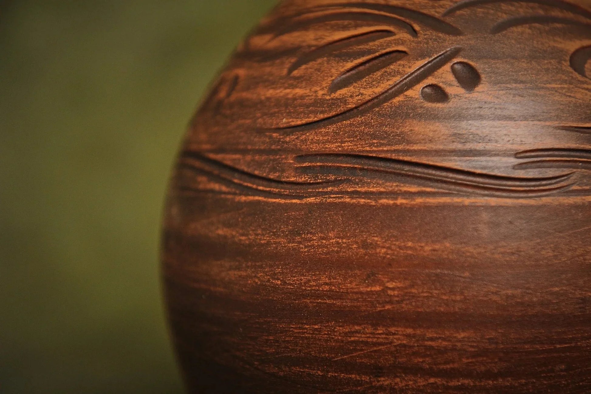 Close-up of handcrafted brown clay ceramic jug with carved details, artisan homeware
