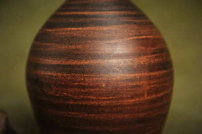 Close-up of handmade red clay jug with natural textured surface, artisan pottery home décor