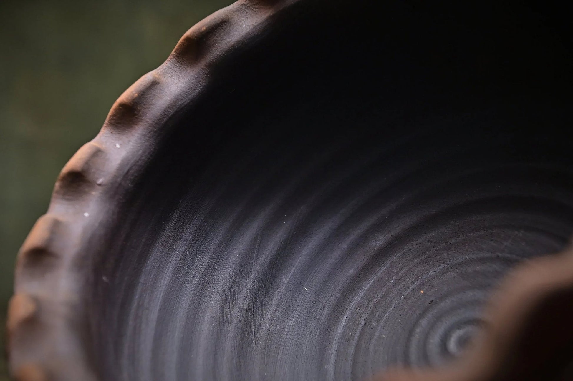 Close-up of handmade ceramic clay bowl with textured rim, artisan pottery home decor
