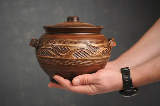 Handmade ceramic pot with lid and handles, artisan clay cookware with carved design