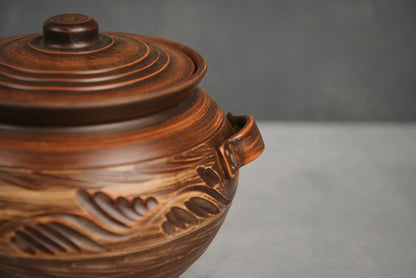 Handmade ceramic pot with lid and handles, brown artisanal clay cookware, leaf pattern