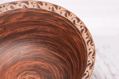 Handmade clay bowl with rustic brown finish and decorative rim, artisan ceramics homeware