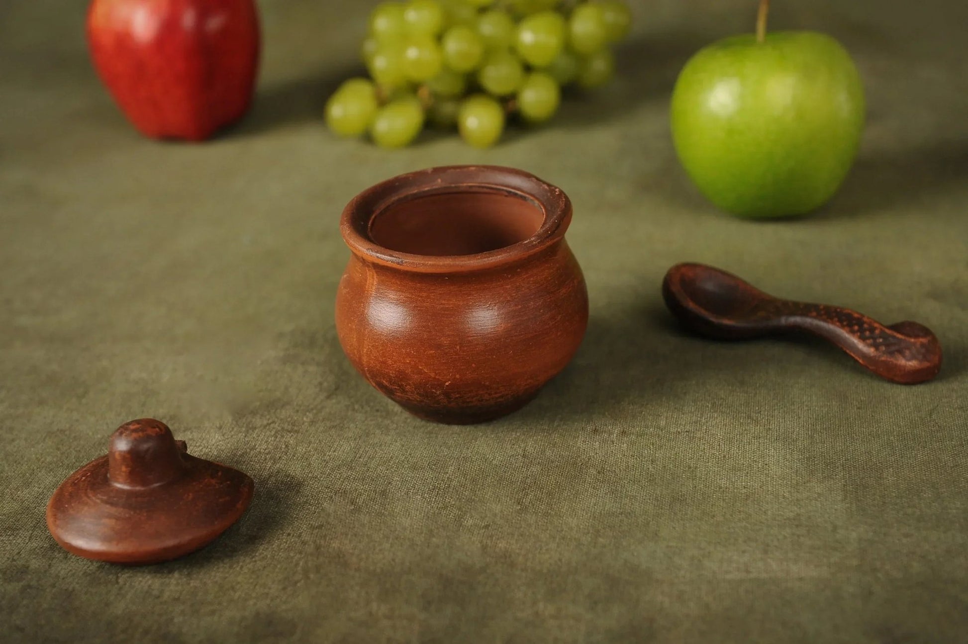 Handmade clay salt bowl with lid and spoon on green cloth, artisan homeware by clayproductsshop