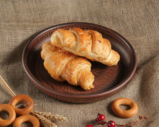 Handmade brown clay plate with croissants, rustic artisan ceramic homeware