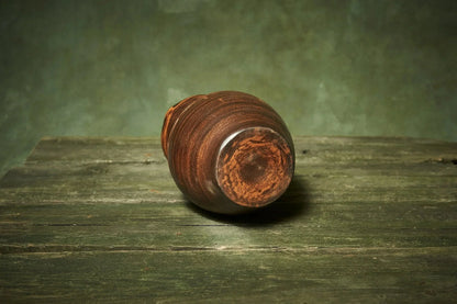 Handmade brown ceramic pitcher on rustic wooden table, artisan clay homeware