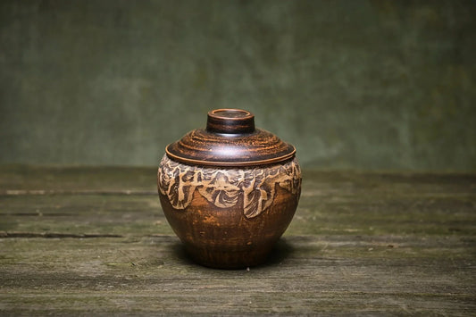 Handmade small ceramic pot with lid, artisan Ukrainian pottery bakeware on rustic wood