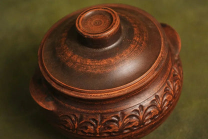 Handmade brown ceramic pot with lid, decorative floral pattern, clay kitchenware